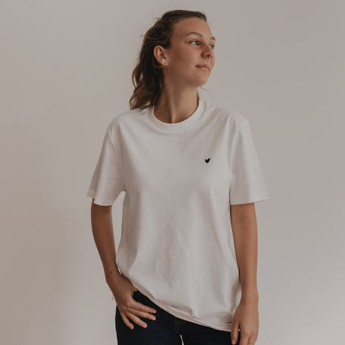 Frau trägt weißes Shirt mit schwarzem Herzprint vorne, locker und casual