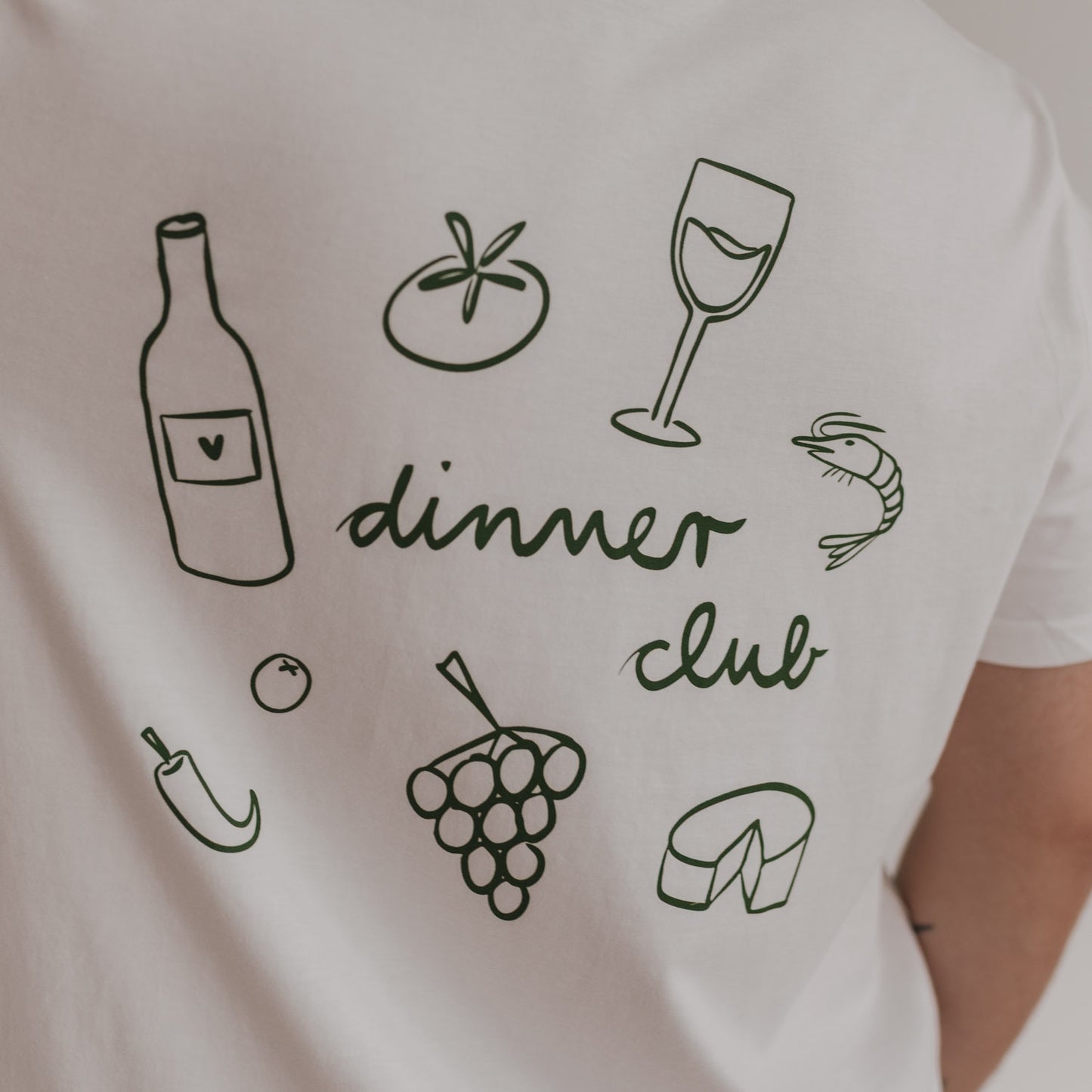Detailansicht Rückenprint: grünes Dinner Club Design mit Wein, Tomate, Trauben & Käse.