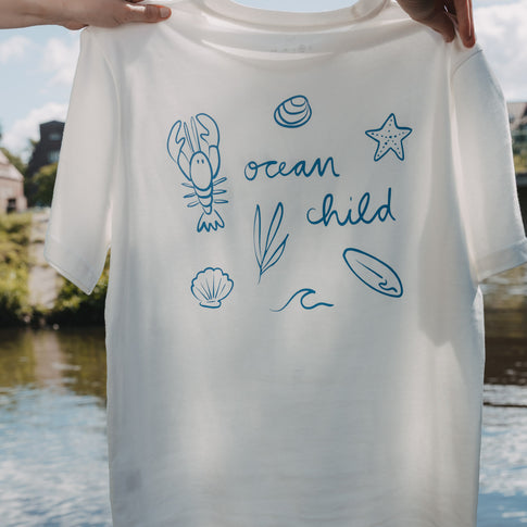 Weißes T-Shirt mit „Ocean Child“ Rückenprint und Meeresmotiven, frontal gehalten