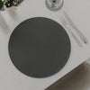 Dunkelgraues rundes Platzset mit eingeprägtem Herzmotiv, stilvoll gedeckt mit Besteck auf weißer Tischdecke.