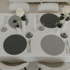 Elegant gedeckter Tisch mit wendbaren runden Platzsets in Grau und Herzprägung für eine stilvolle Tischdeko.