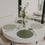 Rund gedeckter Tisch mit grünen wendbaren Platzsets und Blumendekoration.