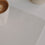Creme Schreibtischunterlage mit Herz, Kaffeetasse im Detail auf modernem Schreibtisch