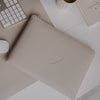 Laptophülle Taupe mit Herzprägung und Reißverschluss auf Schreibtisch neben Tastatur, Maus und Kaffee