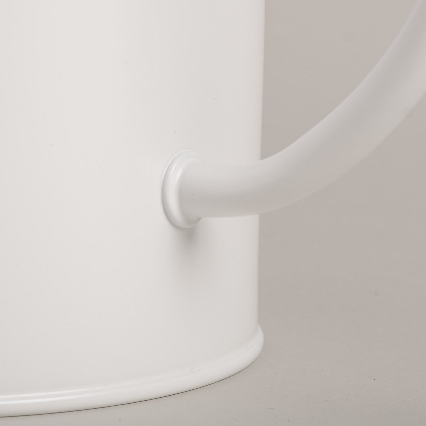 Nahaufnahme der Henkelverbindung der weißen Gießkanne aus Metall