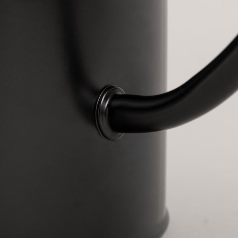 Nahaufnahme der Herzprägung auf der Gießkanne in Schwarz