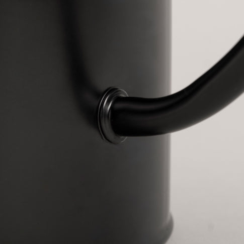 Nahaufnahme der Herzprägung auf der Gießkanne in Schwarz