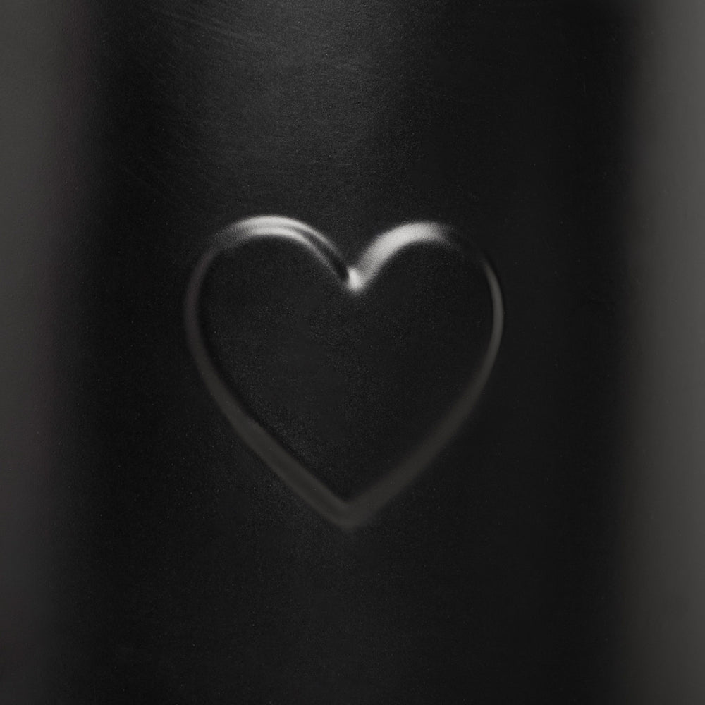 Nahaufnahme der Herzprägung auf der Gießkanne in Schwarz