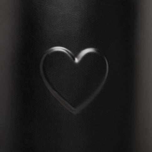 Nahaufnahme der Herzprägung auf der Gießkanne in Schwarz