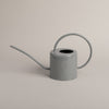 Graue Metallgießkanne mit langem Ausguss und rundem Griff – schlichtes Design mit geprägtem Herzmotiv.