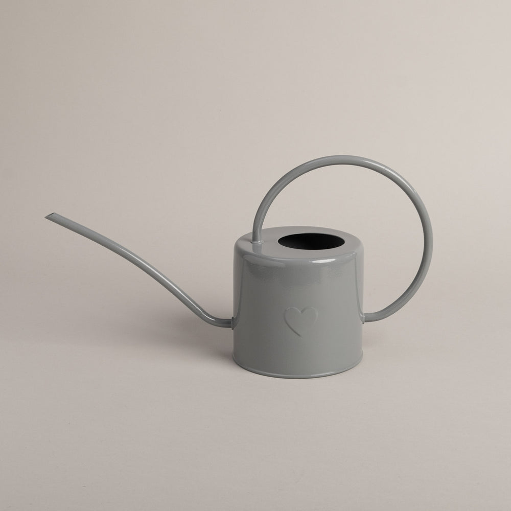 Graue Metallgießkanne mit langem Ausguss und rundem Griff – schlichtes Design mit geprägtem Herzmotiv.