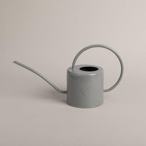 Graue Metallgießkanne mit langem Ausguss und rundem Griff – schlichtes Design mit geprägtem Herzmotiv.