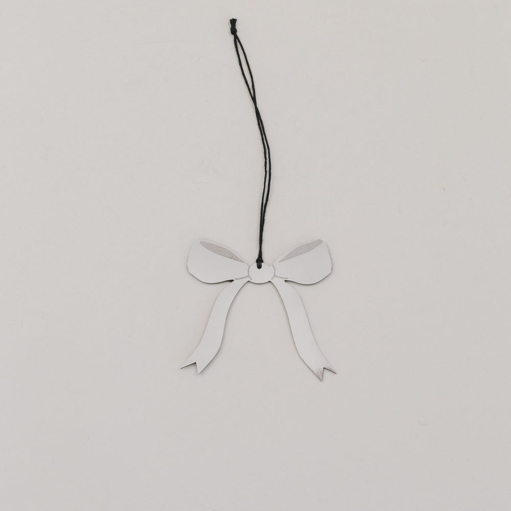 Einzelner Schleifenanhänger aus silberfarbenem Metall mit schwarzem Band auf hellem Untergrund.