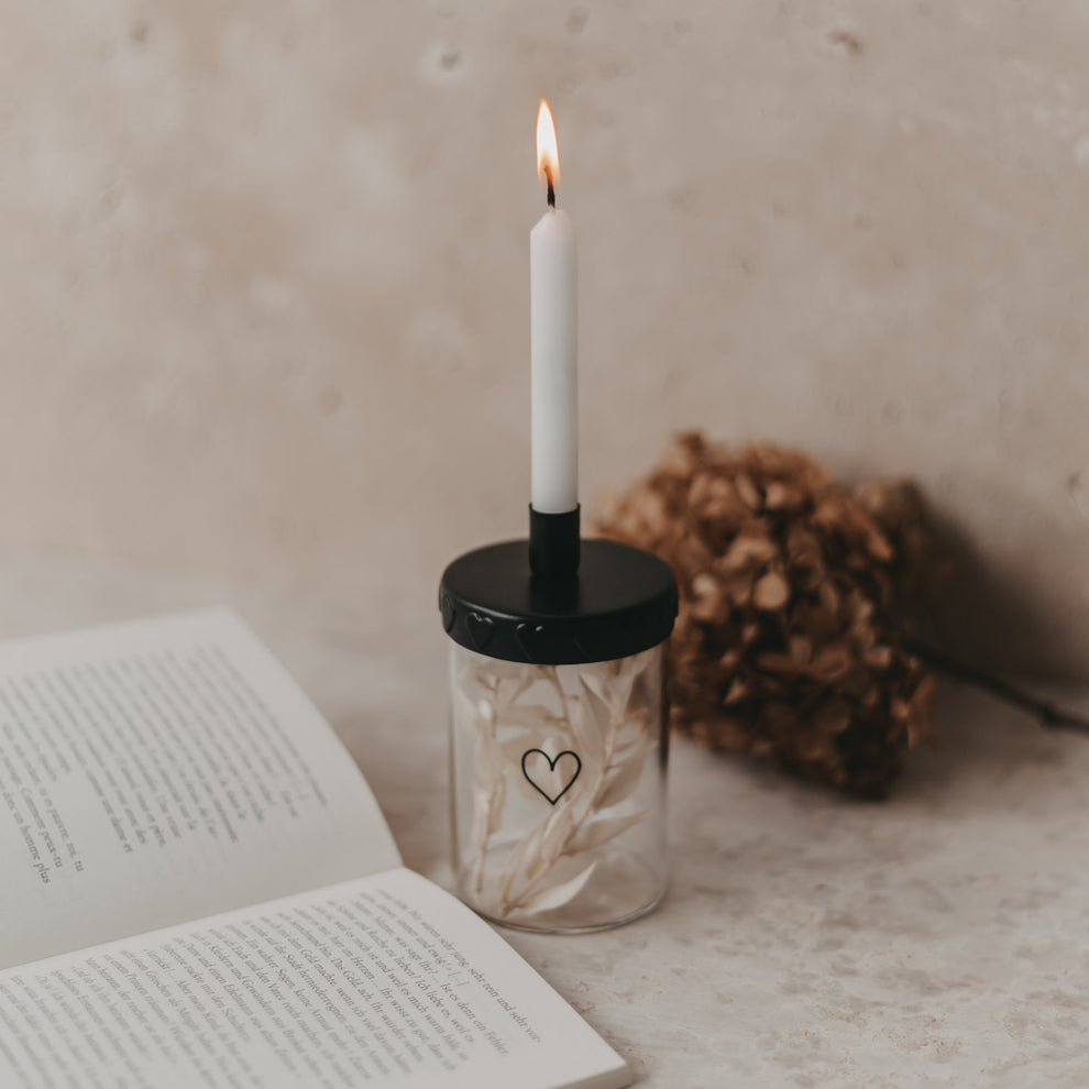 Kerzenhalter mit brennender Kerze, Buch & Deko, Mini-Vorratsglas mit schwarzem Kerzenhalter und brennender Tannenbaumkerze.