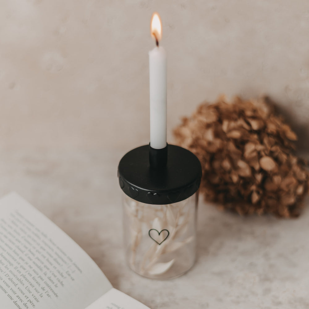 Stimmungsbild mit brennender Kerze:
Kerzenglas mit Mini-Vorratsglas, Deko und brennender Tannebaumkerze.