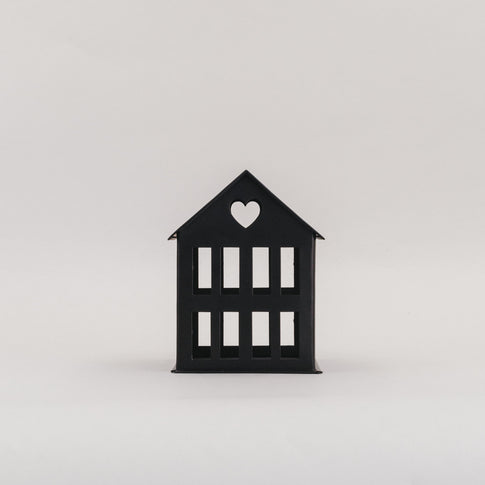 Schwarzes Metallhaus Mini mit Herz im Dach vor hellem Hintergrund – schlichtes Dekoelement aus Metall.