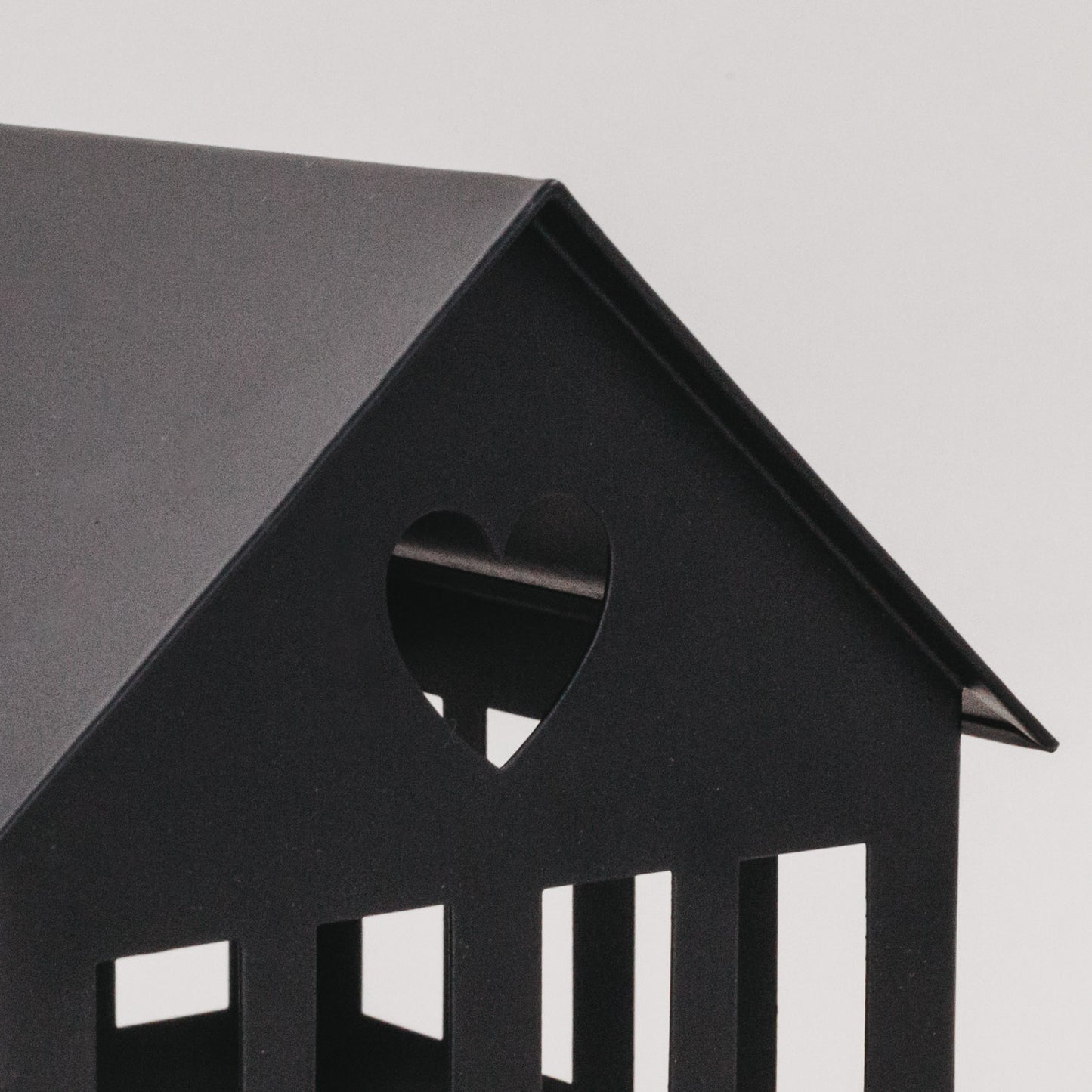 Detailaufnahme des schwarzen Metallhauses mit Herz im Dach – feine Verarbeitung und modernes Design.