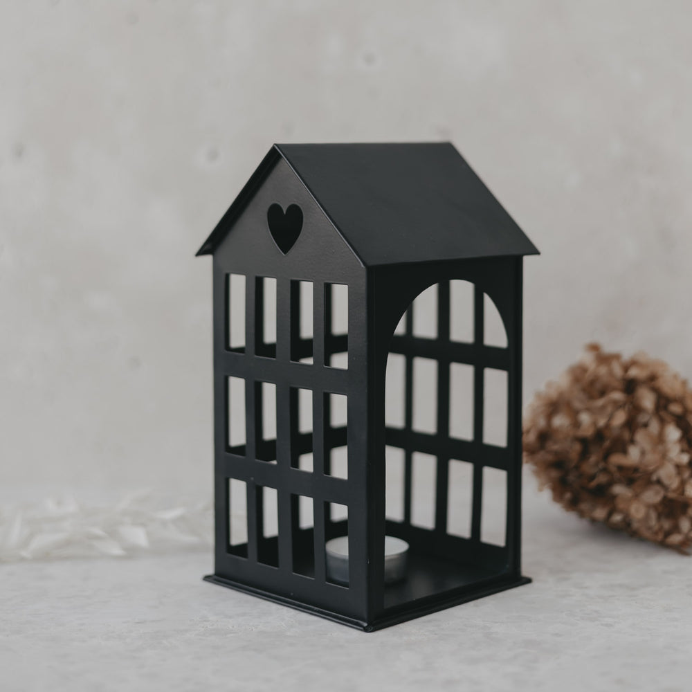Metallhaus Mittel Schwarz mit Herz im Dach und Teelicht, modernes Dekoelement auf hellem Untergrund.
