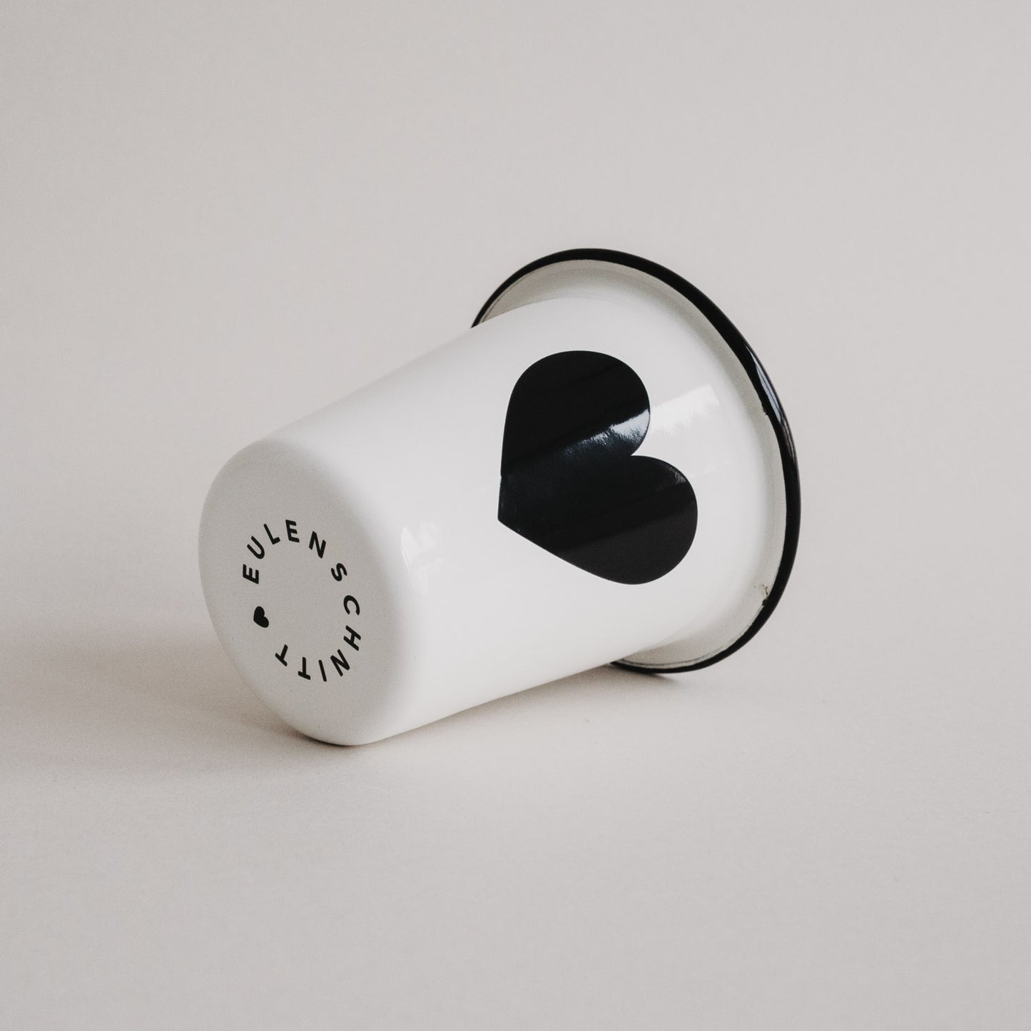 Emaille Tasse Herz seitlich liegend mit Eulenschnitt Logo – minimalistisches Design in Schwarz-Weiß.