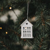 Weißer Hausanhänger aus Metall mit Herzdetail als Weihnachtsbaumschmuck am Tannenbaum
