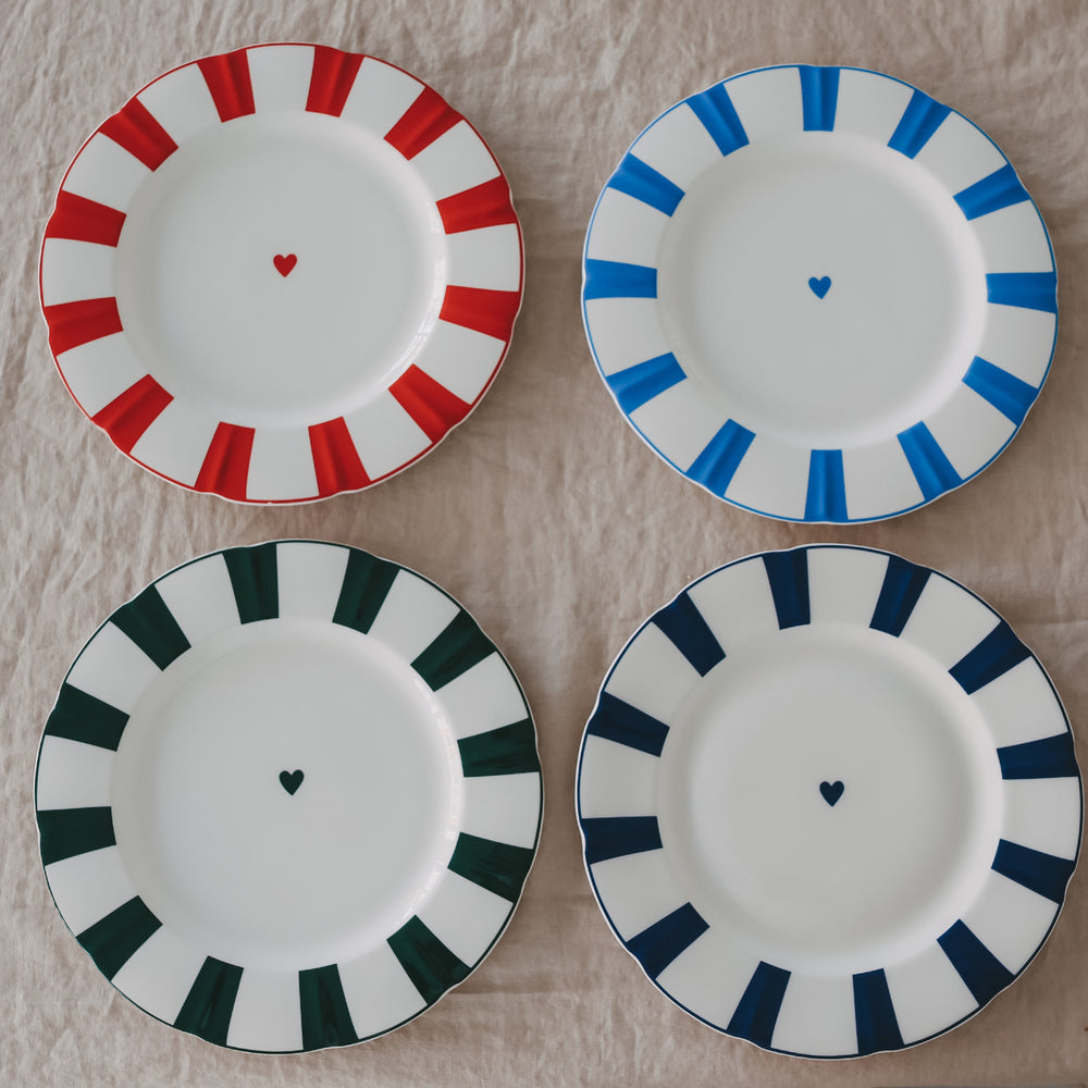 4 Porzellanteller mit gewelltem Rand, Streifenmuster und Herzdetail in verschiedenen Farben Rot, Dunkelblau, Hellblau und Grün, übersichtlich angeordnet