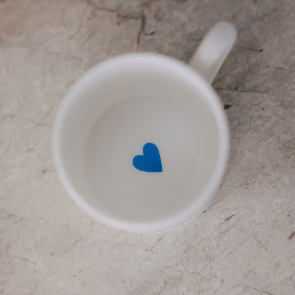 Draufsicht in die Tasse – innen ein kleines hellblaues Herz am Boden.