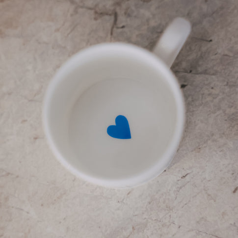 Draufsicht in die Tasse – innen ein kleines hellblaues Herz am Boden.