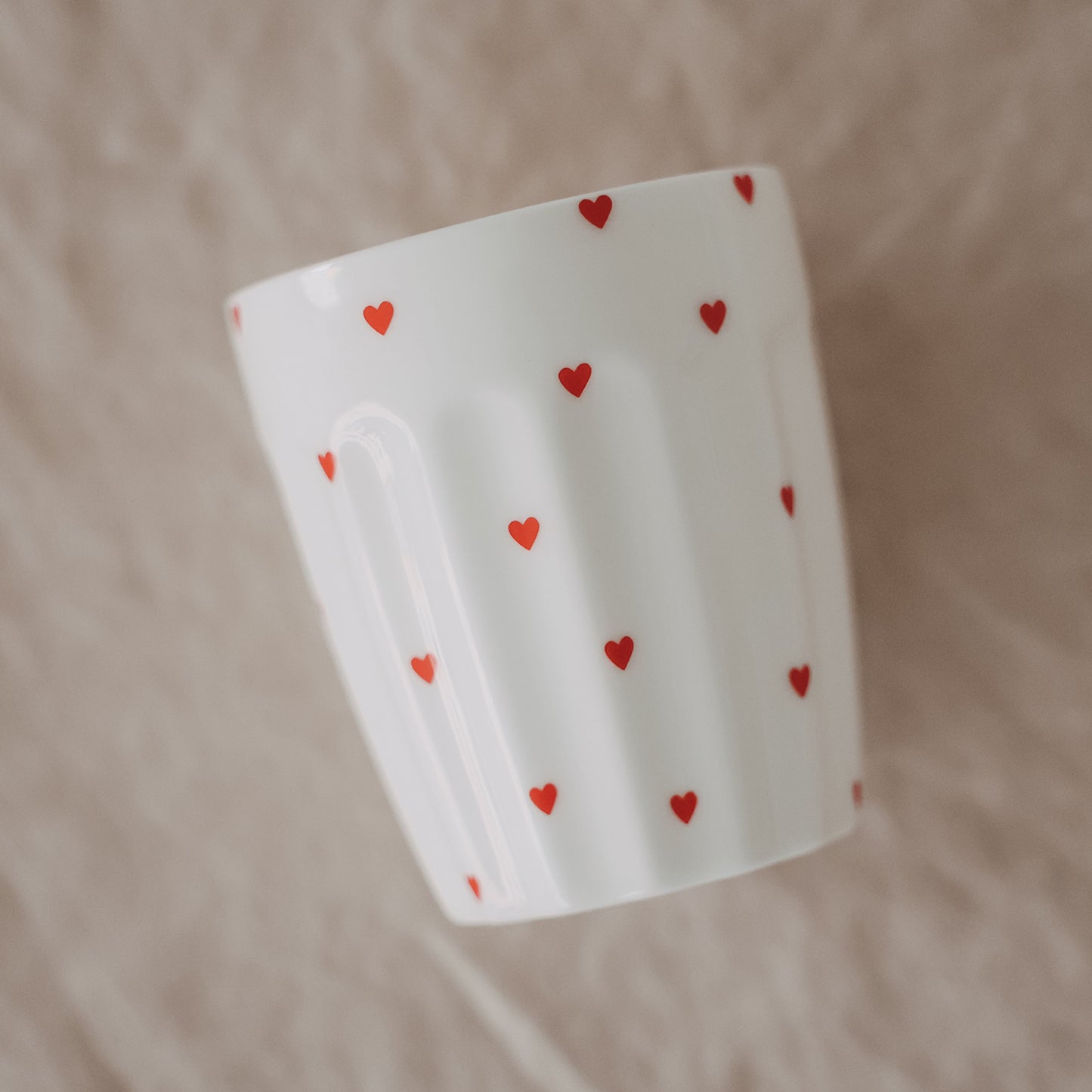 Weißer Becher mit kleinen roten Herzen, modernes minimalistisches Design