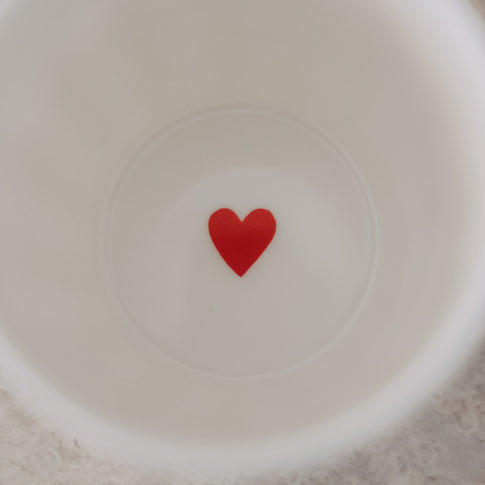 Detailansicht Becherboden mit rotem Herz im Inneren eines weißen Keramikbechers