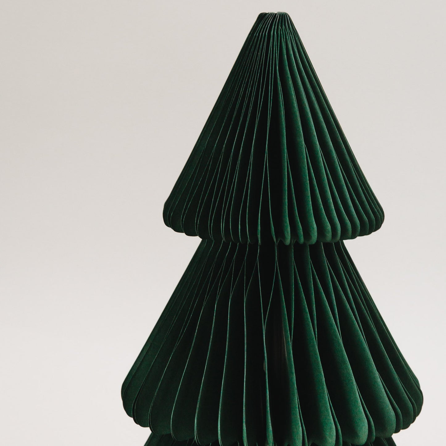 Nahaufnahme einer dunkelgrünen Papiertanne in Wabenoptik – detailreiche Weihnachtsdeko aus Papier mit modernem Look.