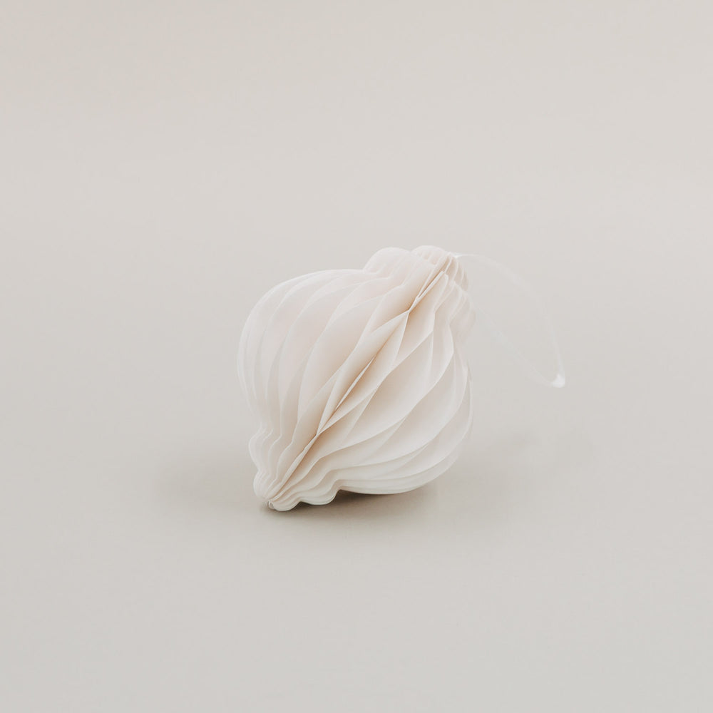 Einzelner Papieranhänger in Naturfarbe mit Wabenoptik und Aufhänger, liegend auf hellem Hintergrund