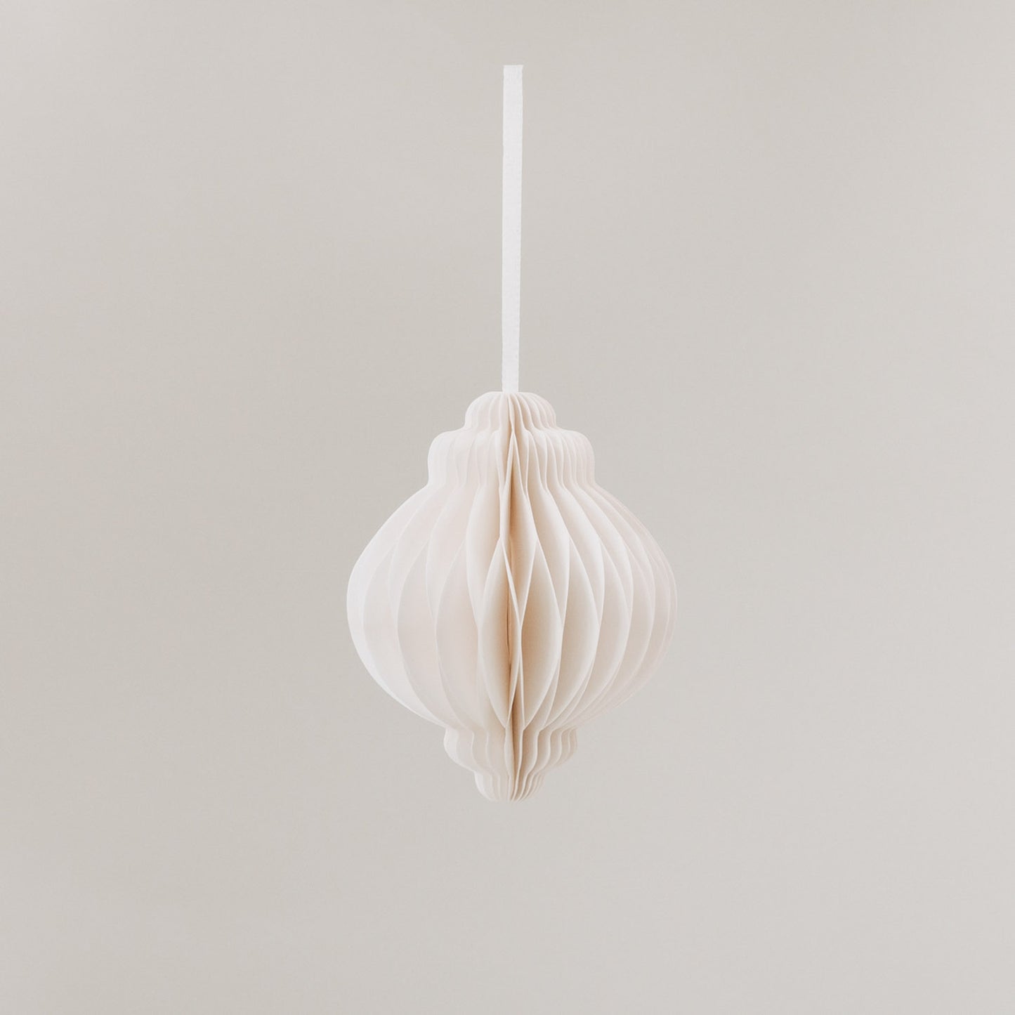 Papieranhänger in Naturfarbe in Tropfenform mit Wabenstruktur und weißem Band zum Aufhängen