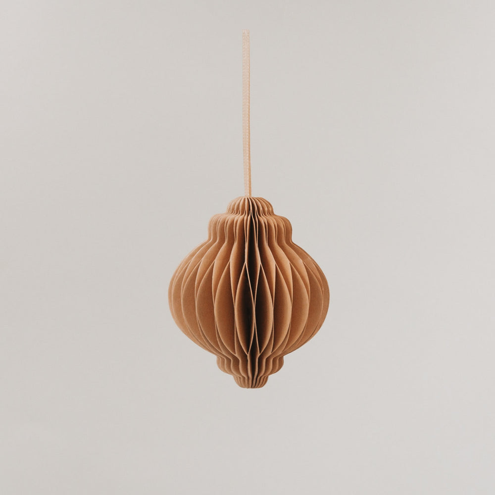 Brauner Papieranhänger mit Wabenstruktur, formschön und aufgehängt vor hellem Hintergrund.