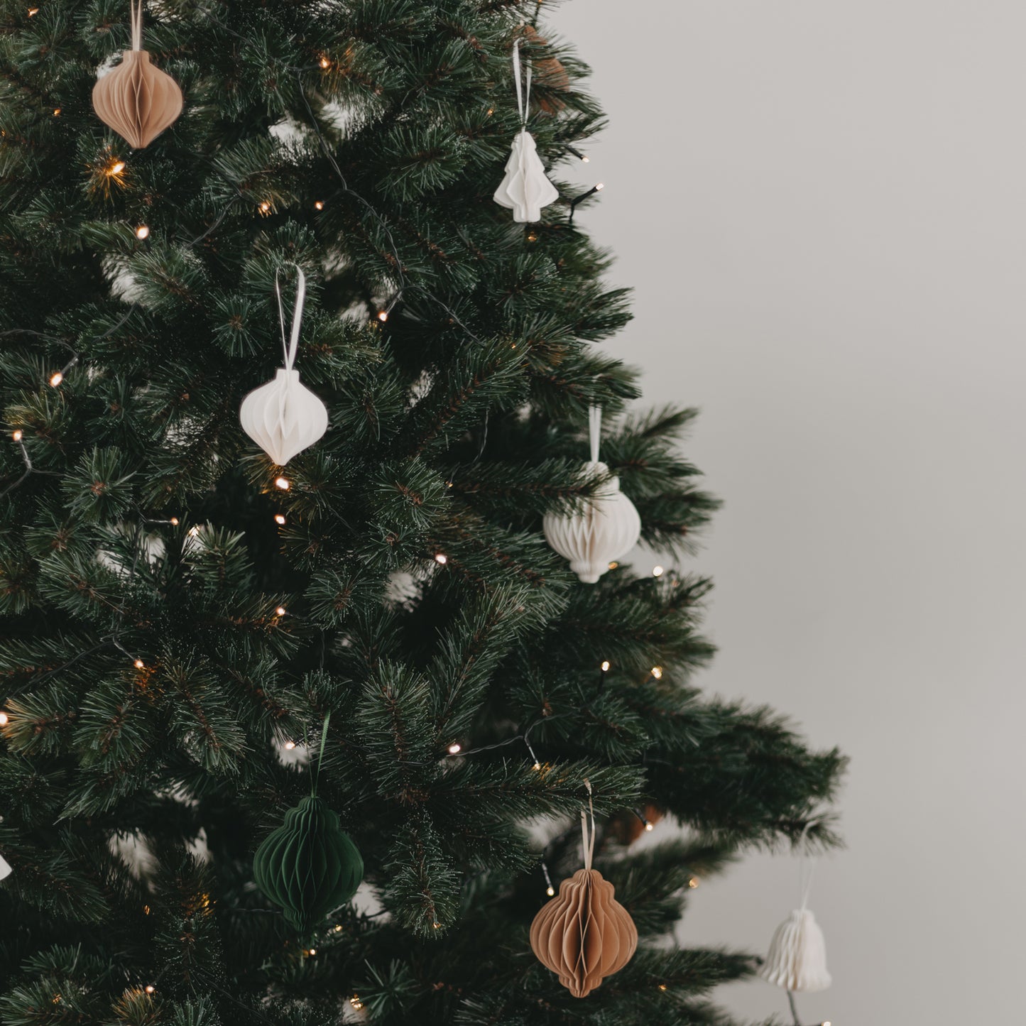 Papieranhänger in Weiß, Dunkelgrün und Braun am Weihnachtsbaum – modernes Farbkonzept zur Adventszeit