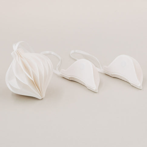 Weißer Papieranhänger geöffnet und zwei zusammengefaltete Anhänger mit Magnetverschluss im Vordergrund