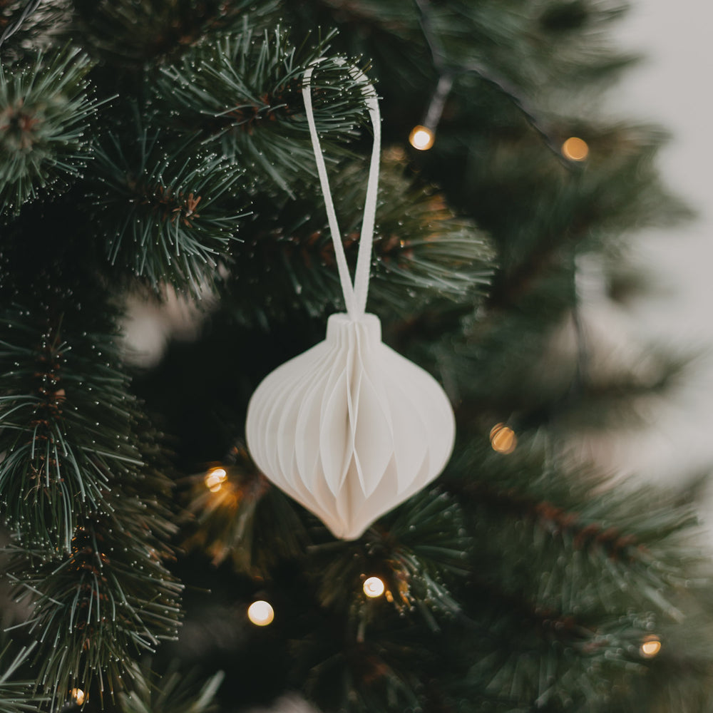 Weißer Papieranhänger am geschmückten Tannenbaum – stimmungsvolle Weihnachtsatmosphäre