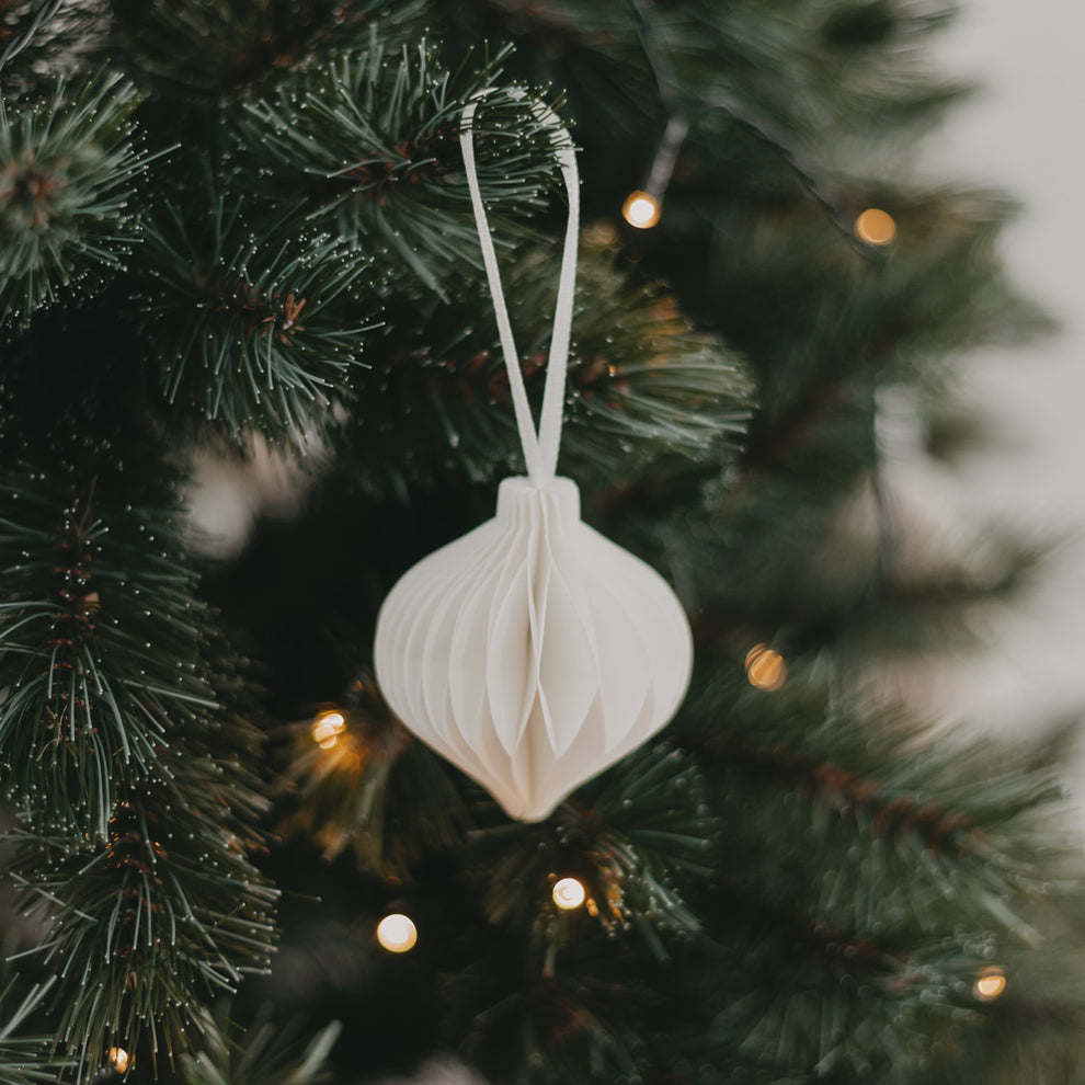 Weißer Papieranhänger am geschmückten Tannenbaum – stimmungsvolle Weihnachtsatmosphäre