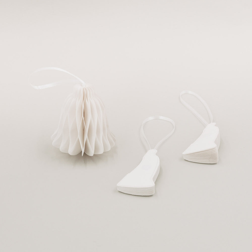 Papierglocke aufgefaltet mit zwei zusammengeklappten Anhängern daneben – zeigt praktischen Magnetverschluss.