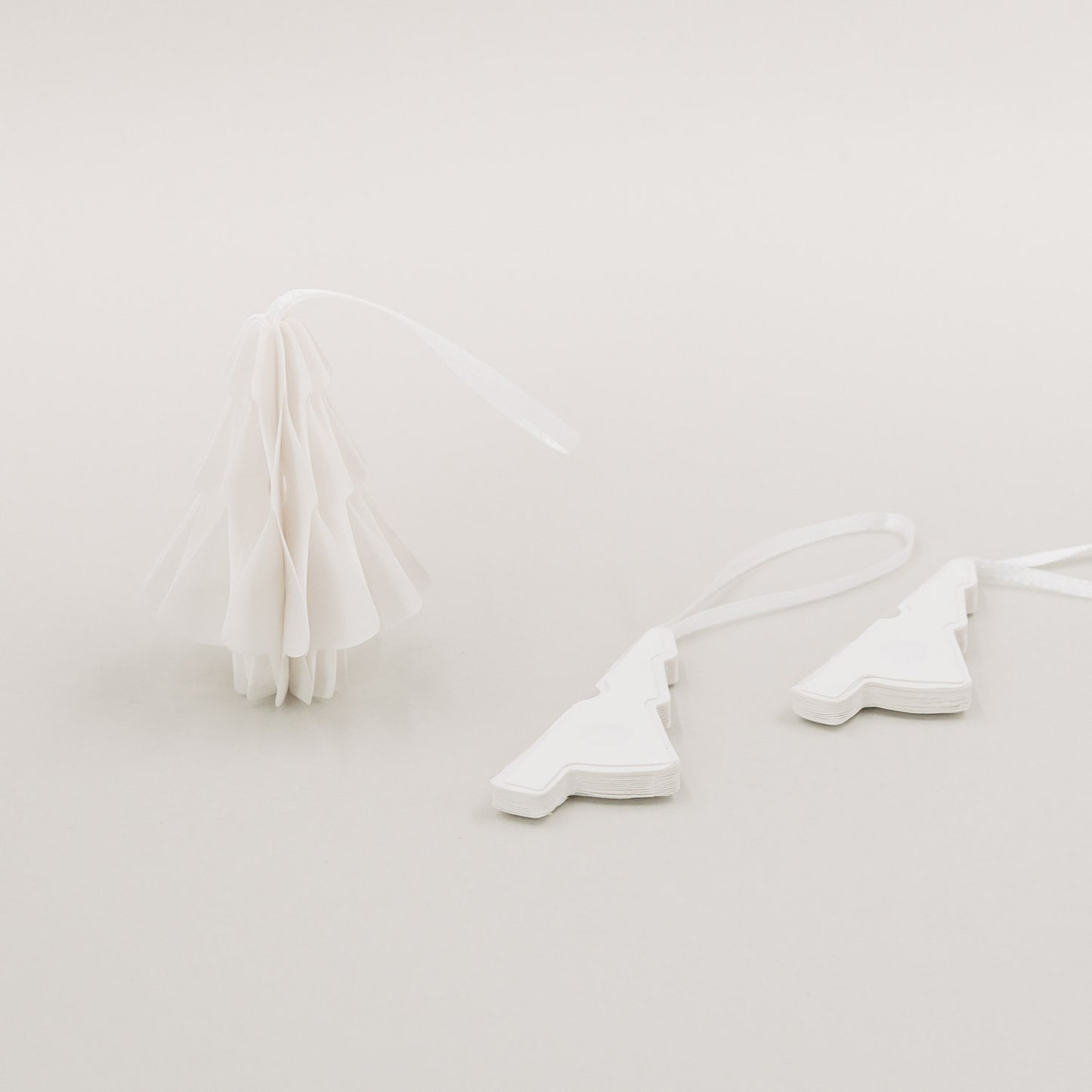 Ein aufgefalteter Tannenanhänger und zwei zusammengelegte Anhänger nebeneinander liegend.