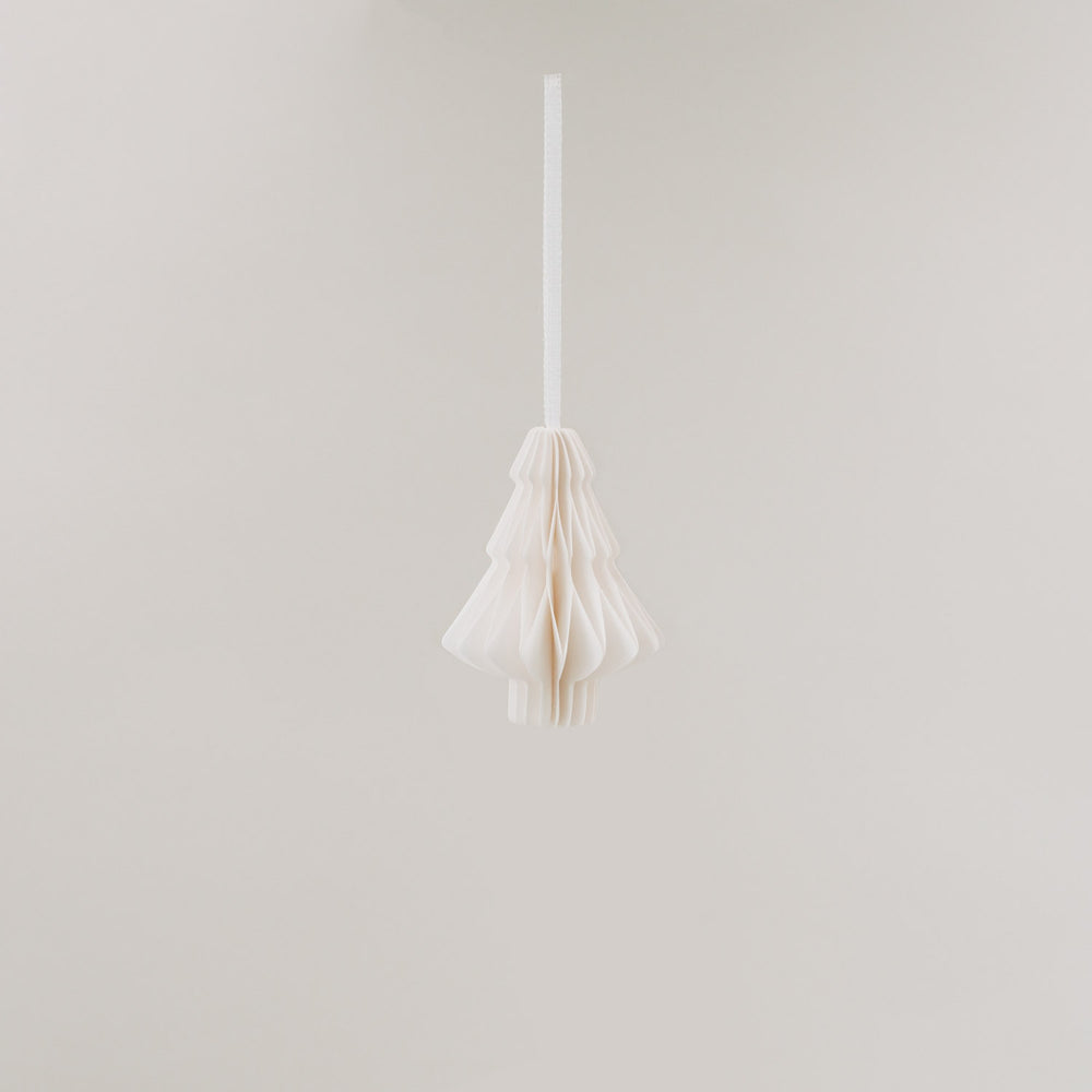 Ein einzelner Papieranhänger in Tannenform hängt frei im Raum, vor hellem Hintergrund schwebend.