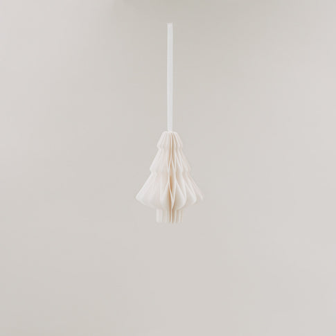 Ein einzelner Papieranhänger in Tannenform hängt frei im Raum, vor hellem Hintergrund schwebend.