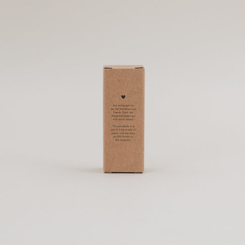 Rückseite der Kraftpapierverpackung mit Beschreibung des Tannen-Anhänger 3er Sets auf Deutsch und Englisch.