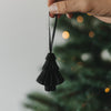 Schwarze Papiertanne als Christbaumschmuck wird in der Hand gehalten