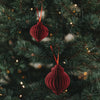 Zwei rote Papieranhänger in Kugelform als festlicher Christbaumschmuck am Weihnachtsbaum