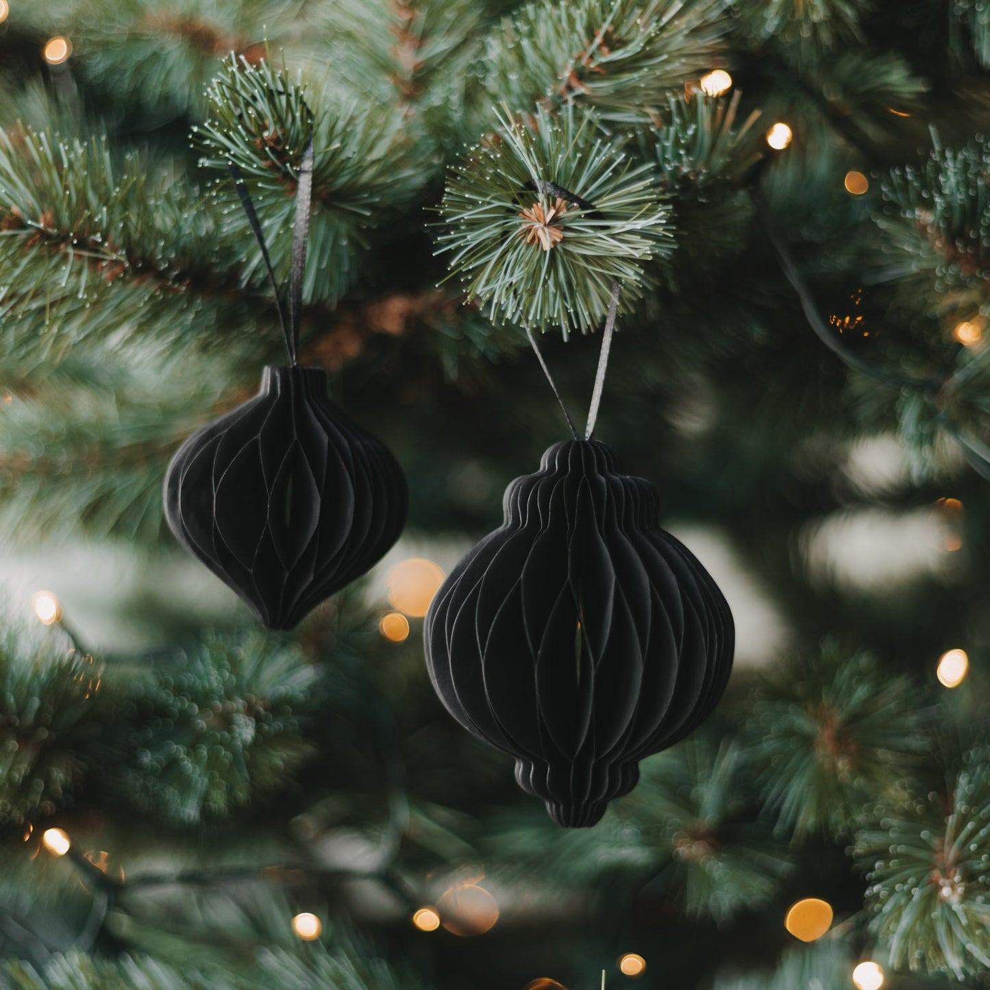 Zwei schwarze Papieranhänger in Kugelform als stilvoller Christbaumschmuck