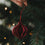 Roter Papieranhänger in Kugelform am Weihnachtsbaum