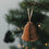 Braune Papierglocke als Weihnachtsanhänger mit Faltoptik am festlich geschmückten Christbaum
