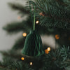 Grüne Papierglocke als Weihnachtsanhänger am festlich geschmückten Christbaum