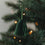 Grüne Papierglocke als Weihnachtsanhänger am festlich geschmückten Christbaum