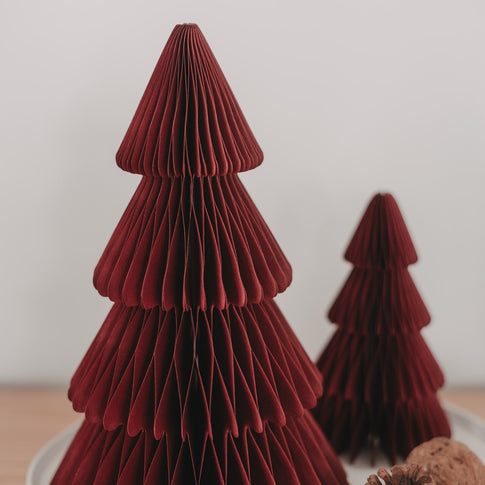 Detailaufnahme dunkelroter Papiertannen in Wabenoptik als stilvolle Weihnachtsdekoration